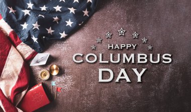 Columbus Günü konseptin kutlu olsun. Klasik Amerikan bayrağı, pusula, kağıt tekne, üzerinde koyu taş arkaplan yazılı ip..