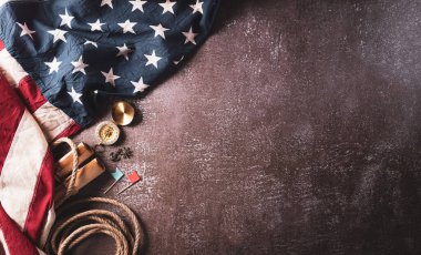 Columbus Günü konseptin kutlu olsun. Klasik Amerikan bayrağı, pusula, kağıt tekne, koyu taştan arka planda ip. Düz konum, kopyalama alanı olan üst görünüm.
