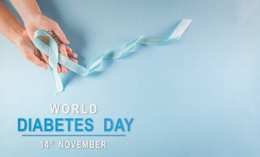 Dünya Diyabet Günü Farkındalık Konsepti. El ele tutuşan mavi kurdele, sembolik yay rengi pastel arka planda diyabet gününde farkındalığı artırıyor, 14 Kasım.