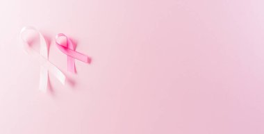 Pastel arka planda pembe kurdeleler, kadınların meme kanseri farkındalığı, sağlık ve tıbbi konseptin sembolü..