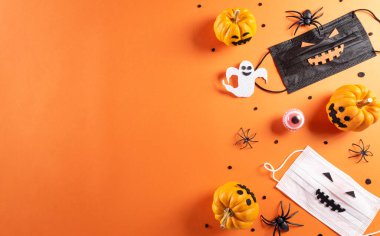 Cadılar Bayramı süslemeleri balkabağı, kağıt yarasalar ve turuncu arka planda siyah örümcekten yapılır. Düz konum, metin için kopyalama alanı olan üst görünüm.