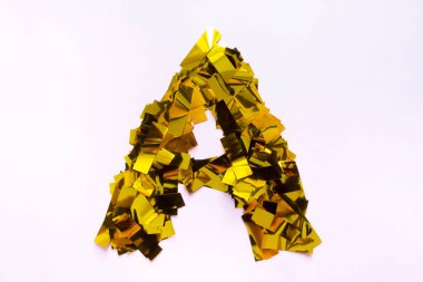 Konfetideki altın şeritlerin pembe arka planında İngiliz ve Rus alfabesinin hacimli bir harfi var. 