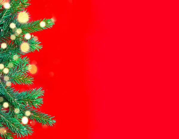 Красном Фоне Слева Видны Ветви Рождественской Елки Красивыми Светящимися Огнями — стоковое фото