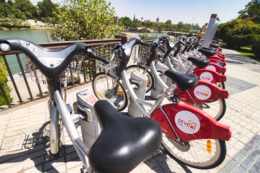 Seville, Spain - 27 August 2019: A row of Sevici bicycles parked in stations in the center of Seville, Spain