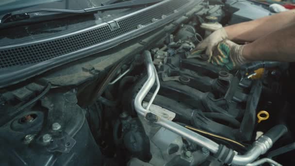汽车维修工人及更换汽车发动机的火花塞，关门 — 图库视频影像