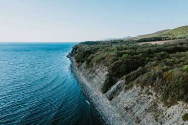 Mavi deniz kıyısının ve kayalıkların havadan panoramik görüntüsü. Karadeniz, vahşi doğa