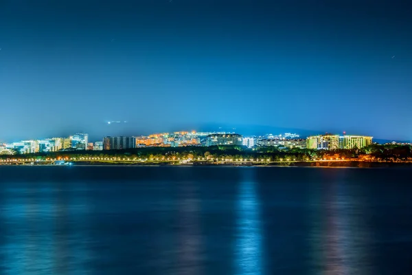 Vista noturna de aterro iluminado de pequena cidade resort Gelendzhik de outro lado da baía à noite — Fotografia de Stock