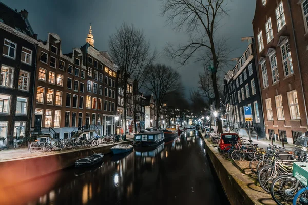 Amsterdam night city water canal with evening lights reflection and old houses, Amsterdam, Netherlands