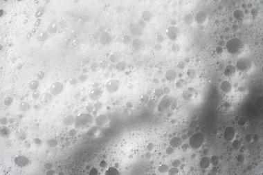 White foam with bubbles texture, soap, detergent or shampoo or cleanser surface, macro shot. Body care concept clipart
