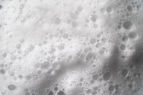 White foam with bubbles texture, soap, detergent or shampoo or cleanser surface, macro shot. Body care concept — Stock Photo, Image