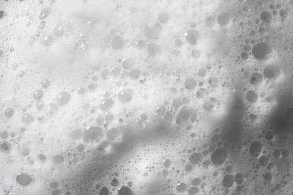 Busa putih dengan tekstur gelembung, sabun, deterjen atau shampo atau permukaan yang lebih bersih, tembakan makro. Konsep perawatan tubuh Stok Foto Bebas Royalti