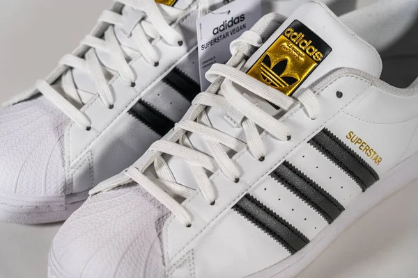 Adidas Superstar - famous sneaker model produced by German manufacturer of sports equipment and accessories Adidas. Retro basketball shoe, in production since 1969 - Moscow, Russia - November 2020 — Stock Photo, Image