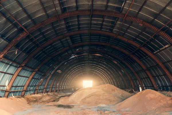 Grote langwerpige hangar met stapels zand voor industrie en bouw — Stockfoto