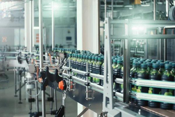 Interior de la fábrica de bebidas industriales. Transportador con embalaje de botellas con zumo —  Fotos de Stock