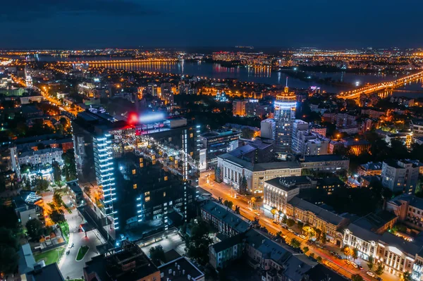 Aerial view night city with illuminated roads, streets and modern buildings in downtown at night dusk — Foto de Stock