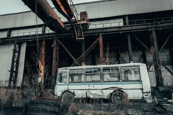 Stary zardzewiały opuszczony autobus w ciemnym, przemysłowym, apokaliptycznym krajobrazie — Zdjęcie stockowe