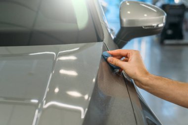 İşçi el temizliği, koruyucu katman ya da otomatik kaplama uygulamadan önce temizlik için mavi killi araba gövdesi. Araba temizleme kavramı