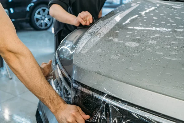 Şeffaf Boya Koruma Filmi ya da araba kaputuna sarılı çakıl önleyici kaplama. Araba temizleme — Stok fotoğraf