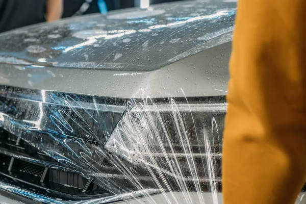Película transparente de protección de pintura o recubrimiento de protección antigrava envuelto en la capucha del automóvil. Detallado del coche — Foto de Stock