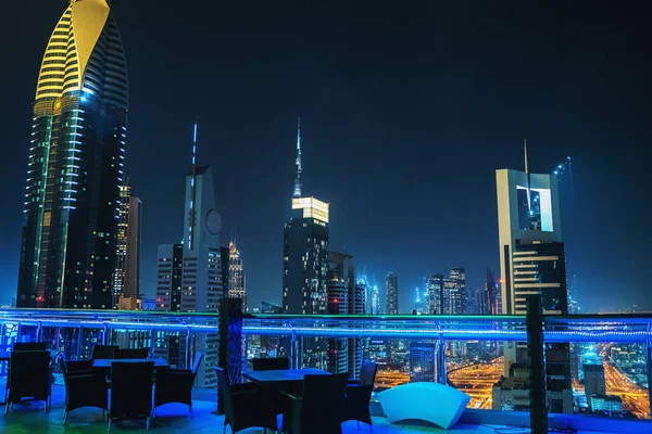 Dubai şehir merkezi gece manzaralı ve ön planda boş restoran masaları, BAE, lüks seyahat ve turizm — Stok fotoğraf