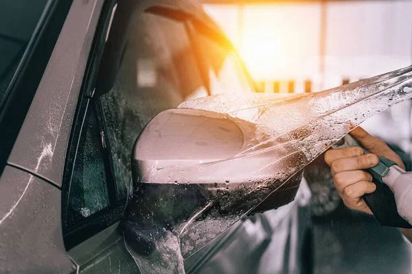 Proceso de instalación de PPF o película de protección de pintura o revestimiento de protección anti-grava en el espejo del coche. Detallado del coche —  Fotos de Stock