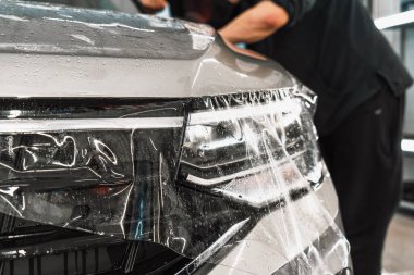 Şeffaf Boya Koruma Filmi veya PPF veya araba kaputuna çakıl önleyici kaplama kurulumu. Araba temizleme