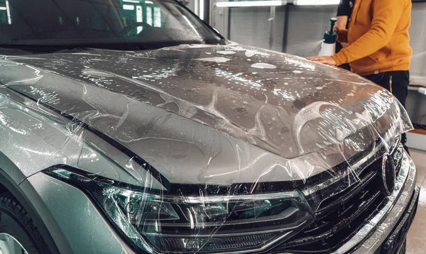 Profesyonel Oto Detaylandırma Merkezi 'nde yeni araca boya koruma filmi ya da PPF kurma işlemi. Çiziklerden ve kaya parçalarından korunmak için ince poliüretan film veya polimer.