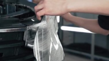 Araba farına ıslak plazma ya da boya koruma filmi takan tamirci koruyucu dış kaplama olarak, kapatın.