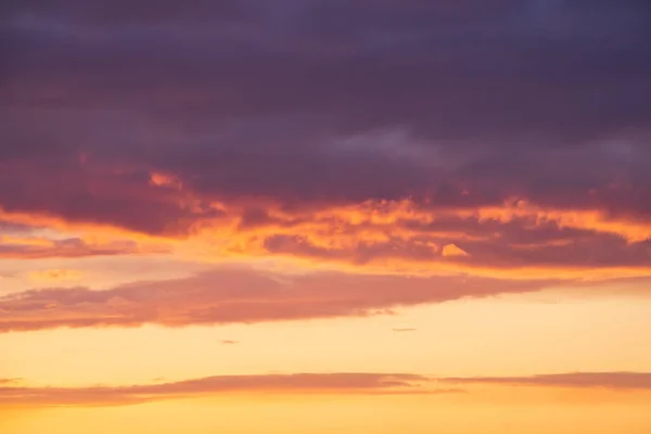 Leuchtend violette oder violette Wolken vor epischem orangefarbenem Sonnenuntergang — Stockfoto