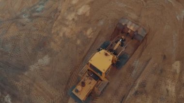 Kum havası manzaralı inşaat sahasında çalışan kazıcı veya buldozer