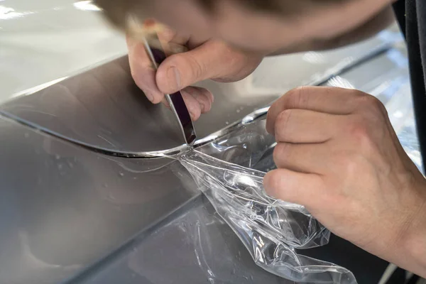 Détaillant coupe avec couteau enveloppé et installé PPF pour film de protection de voiture sur le capot du véhicule — Photo