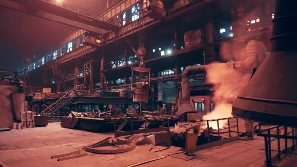 Container with hot iron in foundry metallurgical plant, heavy industry. Large workshop hangar with burning metal and bright smoke, process of cast — Stock Video