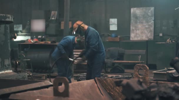 Werknemers in maskers werken in werkplaatsen van metallurgische gieterijen — Stockvideo