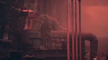 Metalurji dökümhanesinde döküm kalıbı için sıvı demir dolu konteynır işçiler kontrolünde.