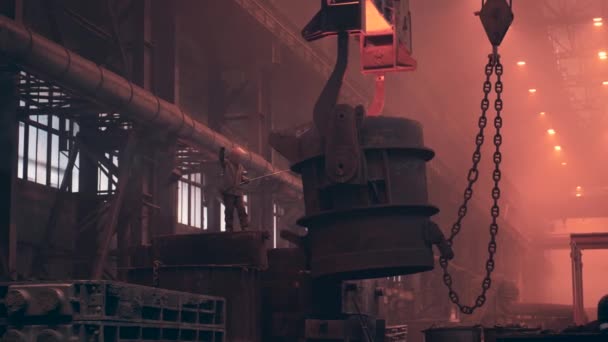 作業者は、冶金鋳造工場で金型を鋳造するための液体鉄で満たされた大きなコンテナを制御します。重工業 — ストック動画