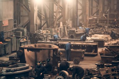 Metalürji fabrikası işçilerinin çalıştığı büyük bir atölye, döküm sonrası çelik fabrikası işlemleri.