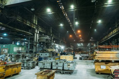 Çelik Fabrikası, işçilerin çalışma süreci, endüstriyel iç mekan, demir üretimli büyük hangar.