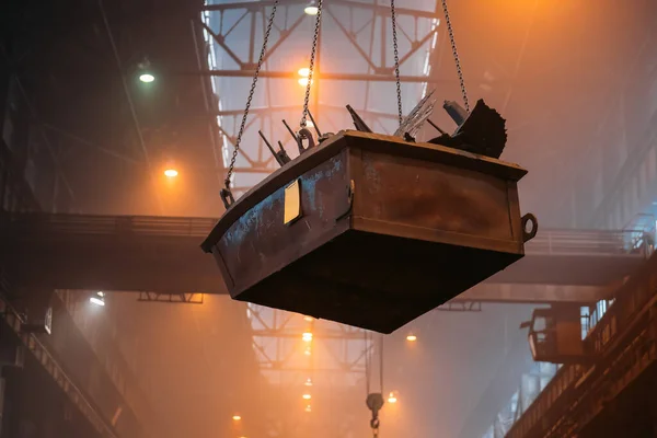 Contenedor con piezas de acero en grúa de carga industrial dentro de planta metalúrgica —  Fotos de Stock