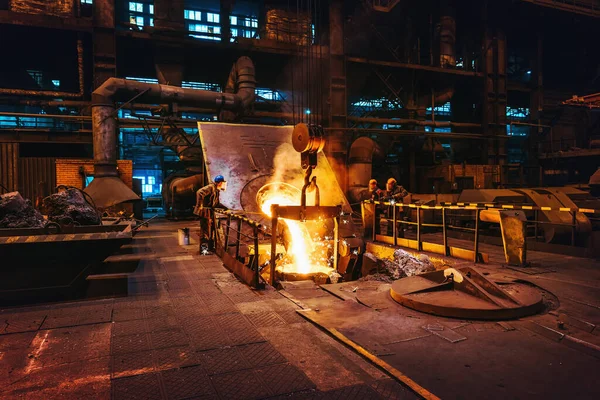 Fonderia interno dell'officina, ferro fuso versando da altoforno in contenitore mestolo e lavoratori fondatori processo di controllo, industria metallurgia pesante — Foto Stock