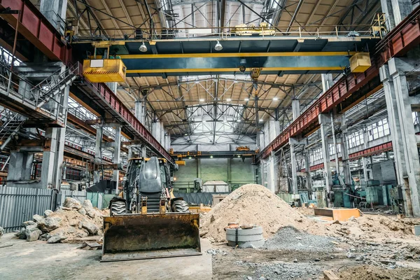 Tractor or excavator with bucket in large industrial workshop at factory, heavy industry concept — Stock Photo, Image