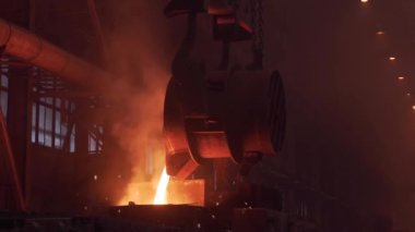 Metal döküm işlemi. Dökümhanede uçan kıvılcımlar saçan parlak erimiş metali kalıba döküyoruz.