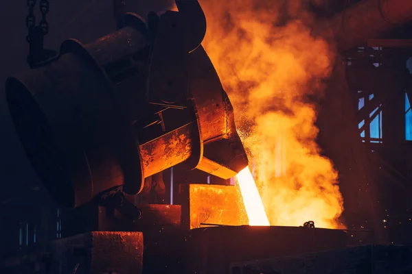 Besi cair logam menuang dari wadah sendok ke cetakan, industri pabrik metalurgi, pengecoran, latar belakang industri berat — Stok Foto
