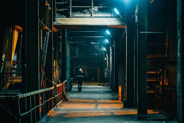 暗い不気味な工業用廊下とともにランプの照明と遠くの労働者のシルエット — ストック写真