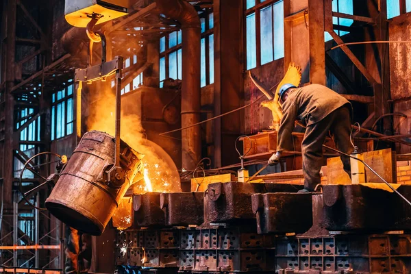 Besi cair logam menuang dari wadah sendok ke cetakan, industri pabrik metalurgi, pengecoran, latar belakang industri berat — Stok Foto