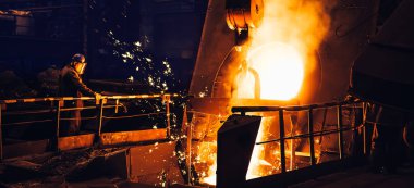 Dökümhanedeki fırından erimiş metal dökülüyor. Çelik fabrikasında demir dökme işlemi, metalürji fabrikası, ağır sanayi