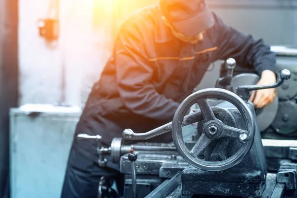 Unerkennbarer verschwommener Arbeiter in Uniform bei der Arbeit mit Metallbearbeitungsmaschine — Stockfoto