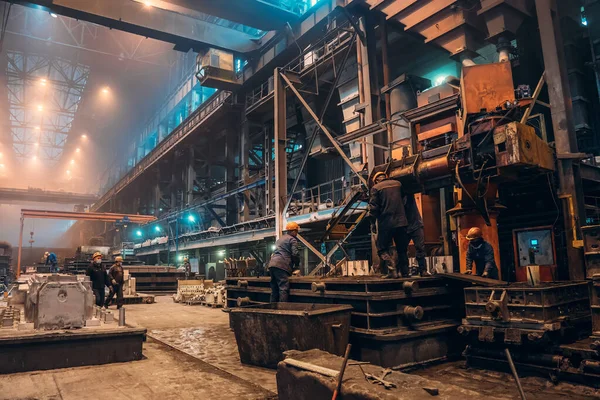 Los trabajadores trabajan con moldes para la fundición de hierro en la fábrica de acero en el taller de fábrica. Fundición, industria pesada, acerías — Foto de Stock