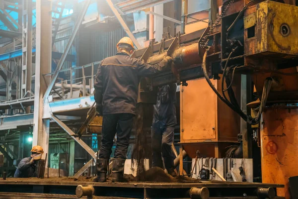 Los trabajadores trabajan con moldes para la fundición de hierro en la fábrica de acero en el taller de fábrica. Fundición, industria pesada, acerías — Foto de Stock