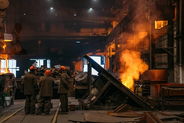Staalproduktie in metallurgische installaties, werkplaats met onherkenbare arbeiders en ondergrondse hoogoven — Stockfoto
