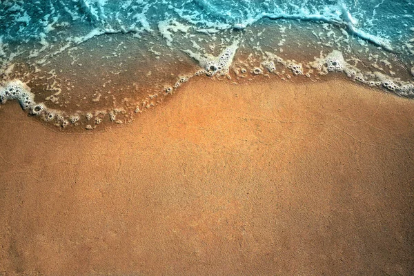 Onda di mare sulla spiaggia di sabbia con schiuma bianca vista dall'alto. Concetto di vacanza estiva con spazio per copiare il testo — Foto Stock